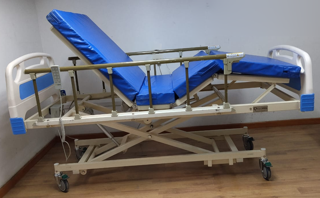 Cama clínica eléctrica Glomed seminueva con colchón de 8 cm, vista articulada. Equipo real; fondo retocado.