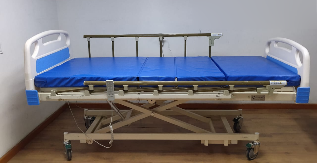 Cama Glomed seminueva con baranda abatida.