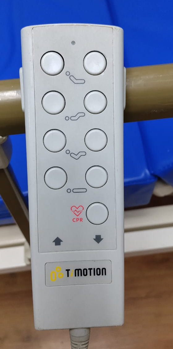 Control de mano TiMOTION original de la cama, con marcas de uso.