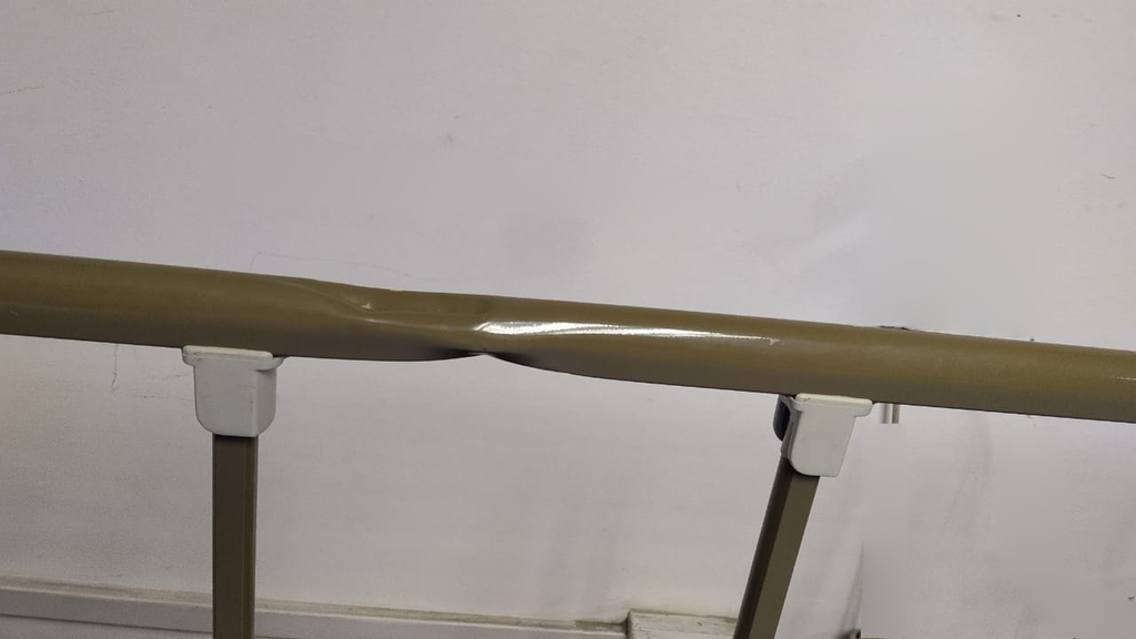 Deformación y abolladura real del tubo superior de la baranda.